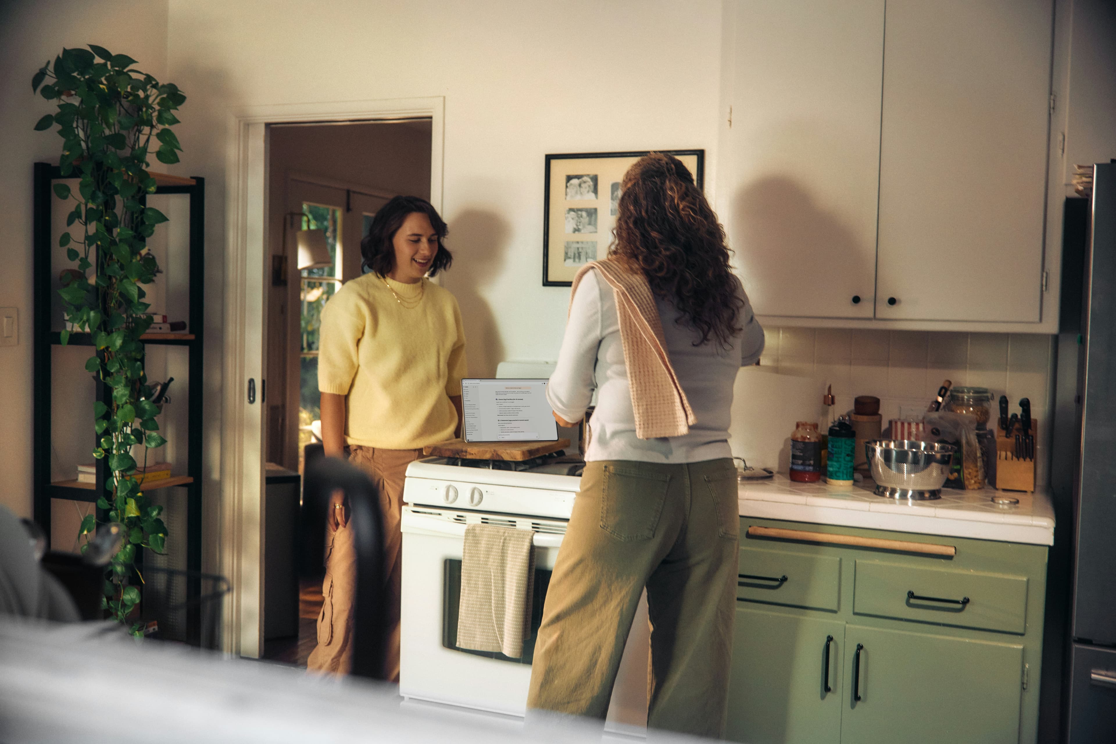 Two adults talking in a kitchen beside a tablet